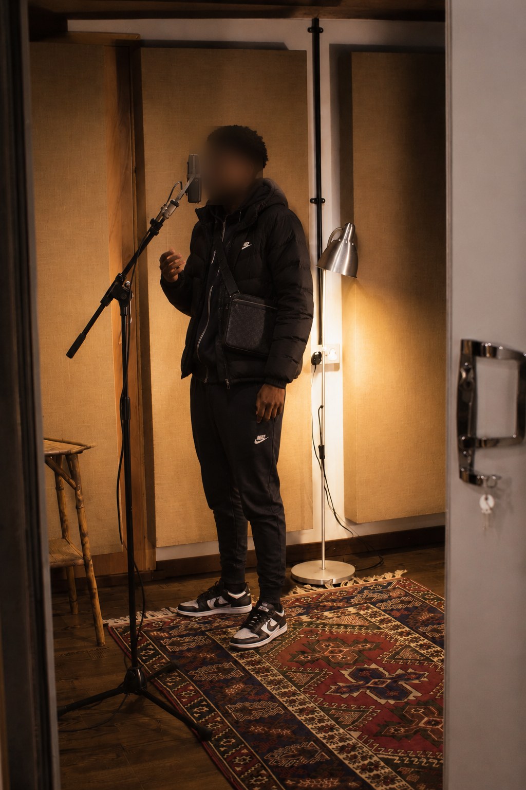 An artist recording vocals in the booth at Studio Solutions
